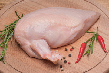 Raw chicken meat on wooden board. Fresh chicken meat. Fresh chicken fillet with a wing on a wooden...