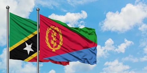 Saint Kitts And Nevis and Eritrea flag waving in the wind against white cloudy blue sky together. Diplomacy concept, international relations.