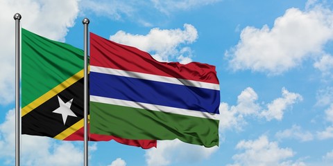 Saint Kitts And Nevis and Gambia flag waving in the wind against white cloudy blue sky together. Diplomacy concept, international relations.