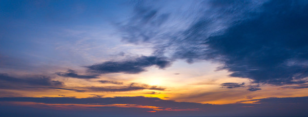 Panorama Sunlight with dramatic sky. Cumulus sunset clouds with sun setting down on dark background.Vivid orange cloud sky.