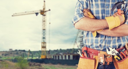 Young man worker in uniform with  tools