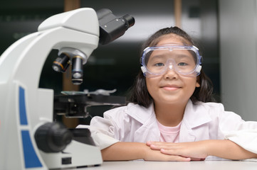 Happy Little child smile and learning in school laboratory