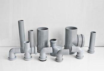 Plastic PVC pipes sewer fittings on a light background.