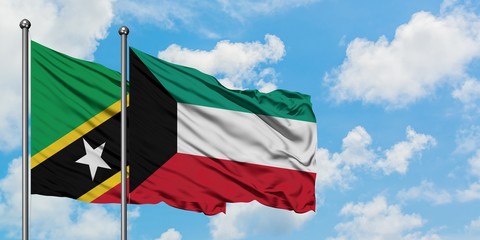 Saint Kitts And Nevis and Kuwait flag waving in the wind against white cloudy blue sky together....