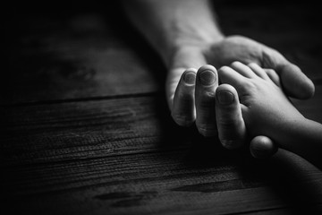 Adult hands holding kid hands, Family Help Care Concept.black and white.