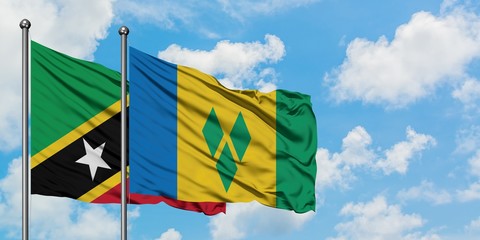 Saint Kitts And Nevis and Saint Vincent And The Grenadines flag waving in the wind against white cloudy blue sky together. Diplomacy concept, international relations.