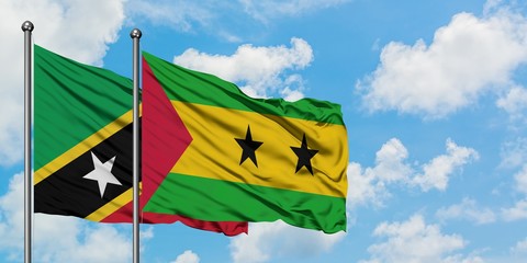 Saint Kitts And Nevis and Sao Tome And Principe flag waving in the wind against white cloudy blue...