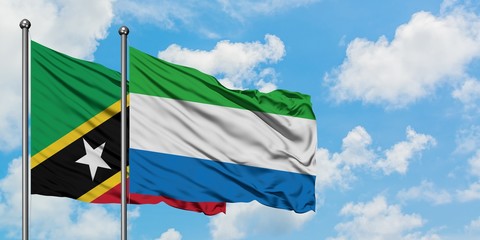Saint Kitts And Nevis and Sierra Leone flag waving in the wind against white cloudy blue sky together. Diplomacy concept, international relations.
