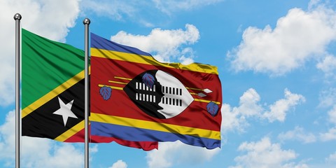 Saint Kitts And Nevis and Swaziland flag waving in the wind against white cloudy blue sky together. Diplomacy concept, international relations.