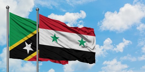 Saint Kitts And Nevis and Syria flag waving in the wind against white cloudy blue sky together....