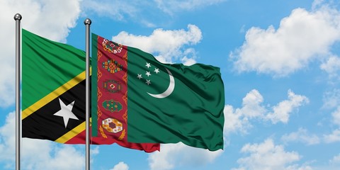 Saint Kitts And Nevis and Turkmenistan flag waving in the wind against white cloudy blue sky...