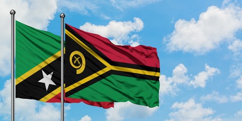 Saint Kitts And Nevis and Vanuatu flag waving in the wind against white cloudy blue sky together. Diplomacy concept, international relations.