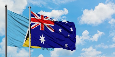 Saint Lucia and Australia flag waving in the wind against white cloudy blue sky together. Diplomacy concept, international relations.