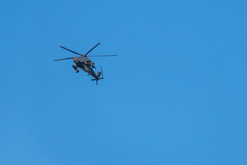 Fototapeta na wymiar Military helicopter flying against a beautiful blue sky