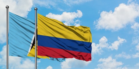 Saint Lucia and Colombia flag waving in the wind against white cloudy blue sky together. Diplomacy concept, international relations.