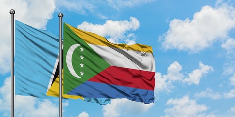 Saint Lucia and Comoros flag waving in the wind against white cloudy blue sky together. Diplomacy concept, international relations.