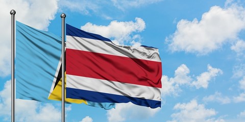 Saint Lucia and Costa Rica flag waving in the wind against white cloudy blue sky together....