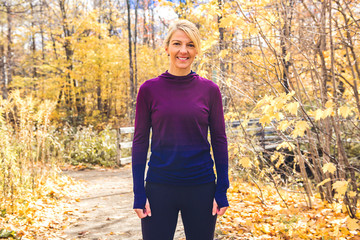 A blond running woman jogging in autumn nature