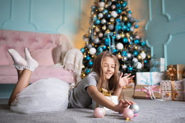 Obraz na płótnie Canvas Girl near the Christmas tree in the studio. Holidays concept. Portrait of a child, teenager.