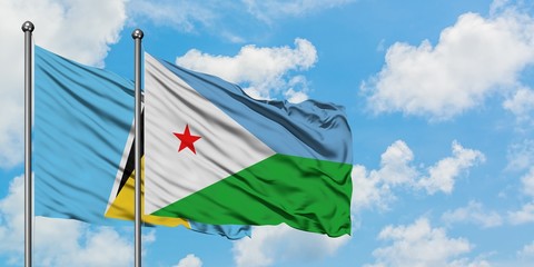 Saint Lucia and Djibouti flag waving in the wind against white cloudy blue sky together. Diplomacy...