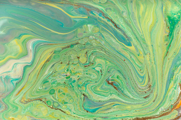 Green pastel marble pattern with golden glitter. Abstract liquid background