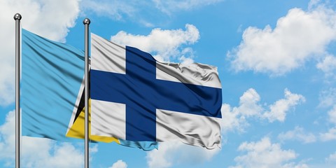 Saint Lucia and Finland flag waving in the wind against white cloudy blue sky together. Diplomacy...