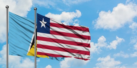 Saint Lucia and Liberia flag waving in the wind against white cloudy blue sky together. Diplomacy concept, international relations.