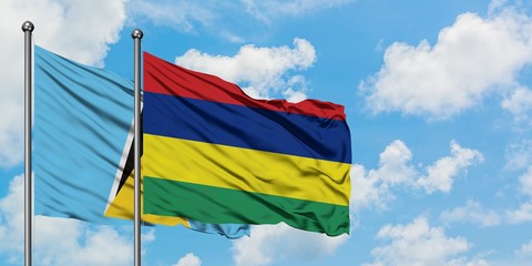 Saint Lucia and Mauritius flag waving in the wind against white cloudy blue sky together. Diplomacy concept, international relations.