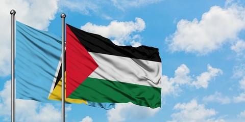 Saint Lucia and Palestine flag waving in the wind against white cloudy blue sky together. Diplomacy concept, international relations.
