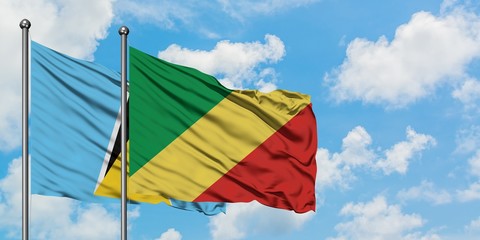 Saint Lucia and Republic Of The Congo flag waving in the wind against white cloudy blue sky together. Diplomacy concept, international relations.