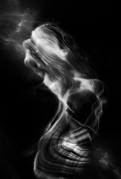Conceptual monochrome black and white avant-garde portrait of a beautiful young girl covered with lines applied by a light brush. Art style creative photo. Advertising, fashion and commercial design.