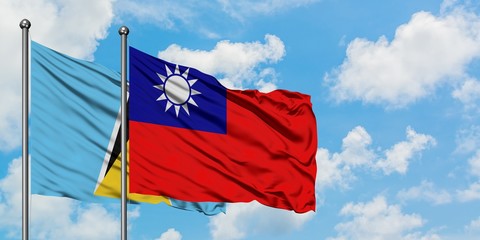 Naklejka na ściany i meble Saint Lucia and Taiwan flag waving in the wind against white cloudy blue sky together. Diplomacy concept, international relations.