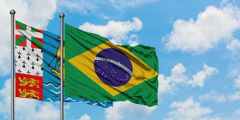 Saint Pierre And Miquelon and Brazil flag waving in the wind against white cloudy blue sky together. Diplomacy concept, international relations.