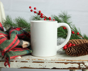Blank white coffee mug mockup on shabby chic white wood background with winter and Christmas accessories