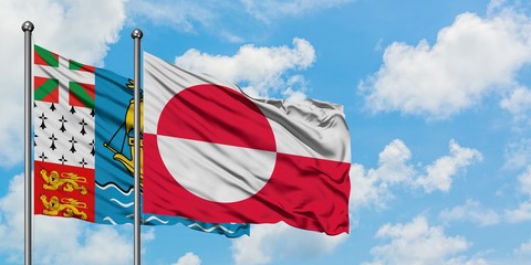Saint Pierre And Miquelon and Greenland flag waving in the wind against white cloudy blue sky...