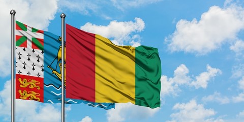 Saint Pierre And Miquelon and Guinea flag waving in the wind against white cloudy blue sky together. Diplomacy concept, international relations.