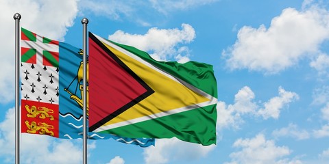 Saint Pierre And Miquelon and Guyana flag waving in the wind against white cloudy blue sky together. Diplomacy concept, international relations.