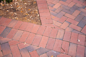 Fototapeta premium In Beaufort, South Carolina, this traditional Southern landscaping choice, of brick pavers in a herringbone pattern with a double soldier course provide a safe and durable walkway or patio surface.