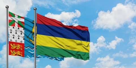 Saint Pierre And Miquelon and Mauritius flag waving in the wind against white cloudy blue sky together. Diplomacy concept, international relations.