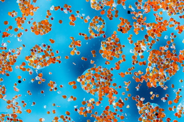 abstract blue background with water drops on glass and glitter particles