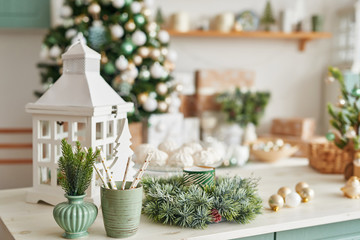 Christmas decor in kitchen. Christmas tableware. Christmas cooking utensils. Bright interior of New Year's cuisine. New Year card template. White Mint Colors Kitchen. Christmas tree in the kitchen.