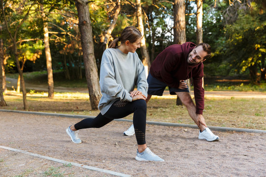 Photo of beautiful sporty couple doing exercises while working out