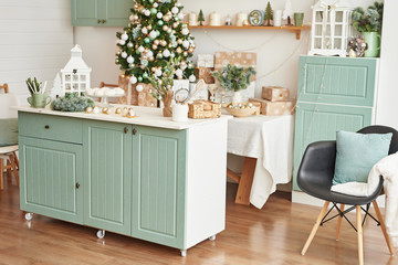 Interior light kitchen with christmas decor and tree. Turquoise-colored kitchen in classic style....