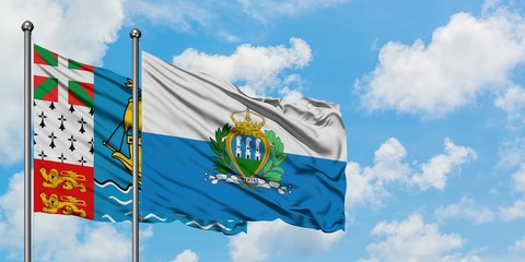 Saint Pierre And Miquelon and San Marino flag waving in the wind against white cloudy blue sky...