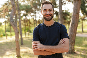 Sports man posing outdoors in nature green park.