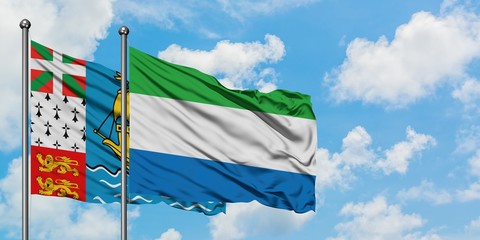 Saint Pierre And Miquelon and Sierra Leone flag waving in the wind against white cloudy blue sky together. Diplomacy concept, international relations.