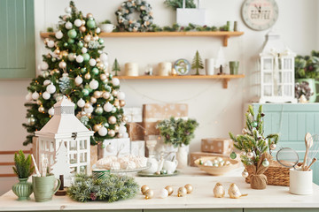Interior light kitchen with christmas decor and tree. Turquoise-colored kitchen in classic style. Christmas in the kitchen. Bright kitchen in mint and white shades with Christmas. 