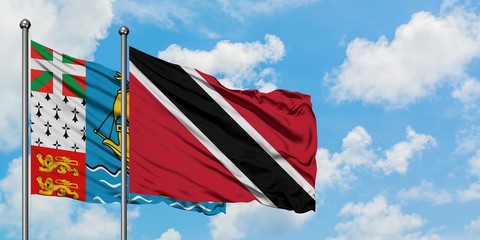 Saint Pierre And Miquelon and Trinidad And Tobago flag waving in the wind against white cloudy blue sky together. Diplomacy concept, international relations.