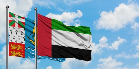 Saint Pierre And Miquelon and United Arab Emirates flag waving in the wind against white cloudy blue sky together. Diplomacy concept, international relations.
