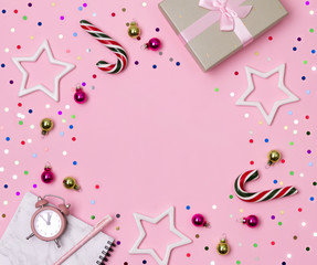 Marble notepad with pen, gift and ornaments on pink background